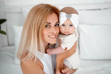 mom and baby hug and kiss, a young mother gently hugs a newborn baby girl holding him in her arms, maternal love and care, a young family, mother and daughter