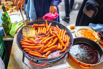 A Basque farmer (Baserritarra) roasting Txistorra (fresh chorizo) to prepare Talos, a traditional street food served during the Day of Saint Thomas.