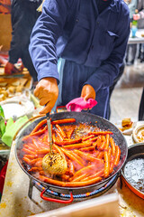 A Basque farmer (Baserritarra) roasting Txistorra (fresh chorizo) to prepare Talos, a traditional street food served during the Day of Saint Thomas.