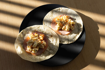 A plate of ham and egg wraps.