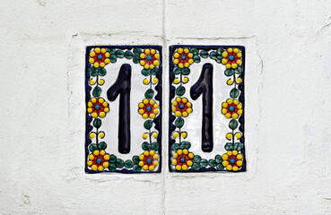 Street sign number 11 on a wite wall in the Tijuca neighborhood, Rio de Janeiro, Brazil