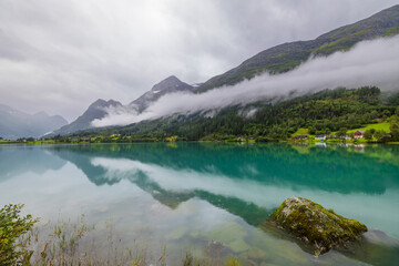 Lake Oldevatnet in the valley of Oldedalen with low hanging clouds and reflection, Norway