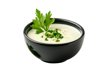 Bowl with creamy Ranch sauce garnished with fresh herbs and chopped green onions isolated on a white transparent background. Concept of fresh and healthy food