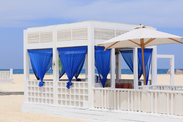 seaside resort beach with white sand and a gazebo for relaxation