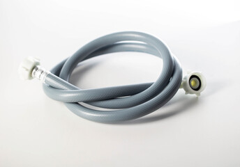 Gray twisted water hose from a washing machine on a white background, isolate, close-up
