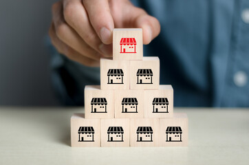 Businessman hand choosing and placing business store franchise wooden black with franchise on the...