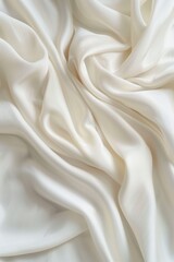 Obraz premium Close-up view of white fabric with subtle texture, folded to reveal intricate folds and creases. Fabric appears smooth, with a slightly rumpled surface. Light gray background provides contrast.