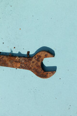 close up of rusty wrench, tool for opening rusty bolts on light blue background. rusty old bolt...