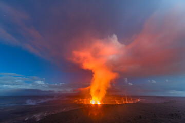 Kilauea volcano erupting during dawn shows the steamy atmosphere the hot liquid creates. © cherylvb