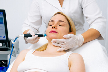 Relaxing beauty treatment in a modern cosmetic clinic. Woman enjoying a hydrolifting procedure, achieving radiant and youthful skin. Perfect for showcasing advanced skincare solutions.