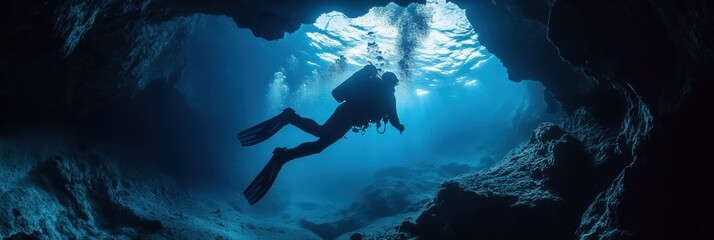 Fototapeta premium Diver exploring underwater rocky cave in deep sea.