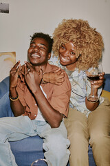Vertical shot of happy friends fooling around while taking photo together