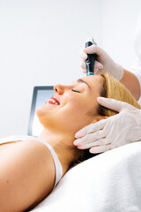 Fototapeta premium Relaxing beauty treatment in a modern cosmetic clinic. Woman enjoying a hydrolifting procedure, achieving radiant and youthful skin. Perfect for showcasing advanced skincare solutions.