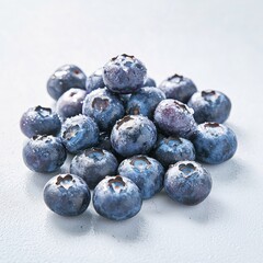 A detailed image of ripe, juicy blueberries glistening with natural moisture on a clean white surface
