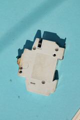 a used or obsolete circuit breaker with a blue background. closeup of electrical protection equipment in a home or industrial building