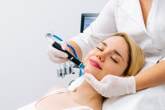 Relaxing beauty treatment in a modern cosmetic clinic. Woman enjoying a hydrolifting procedure, achieving radiant and youthful skin. Perfect for showcasing advanced skincare solutions.