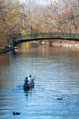 A young couple on the kayak on the creek in the autumn sunset in Madison Wisconsin surrounded by fall foliage 