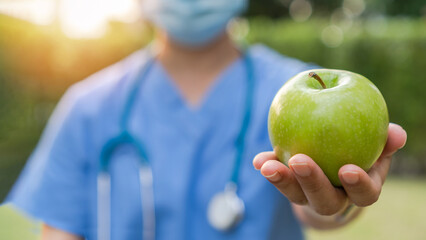 World health day, National nutrition week,an apple a day keeps the doctor away concept by eating high nutritious clean food and healthy nutritional diet with doctor handling green apple to patient