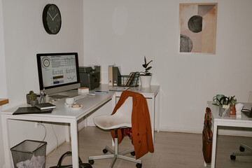 Cozy office with two worktables with office supplies and digital devices