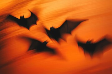 Fototapeta premium Ghostly Black Bats in Motion Against Spooky Orange Sky