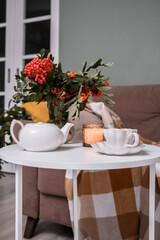 A Cozy Living Room Featuring a Soft Blanket, Lush Green Plants, and a Warm Cup of Coffee
