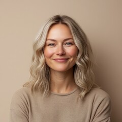 Fototapeta premium closeup portrait of scandinavian smiling woman is 35 years old with blond hair wearing in beige sweater on beige color background, natural beauty