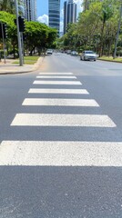 Obraz premium A modern urban landscape features horizontal white lines of a crosswalk on an empty asphalt road in China, showcasing a serene city square without traffic