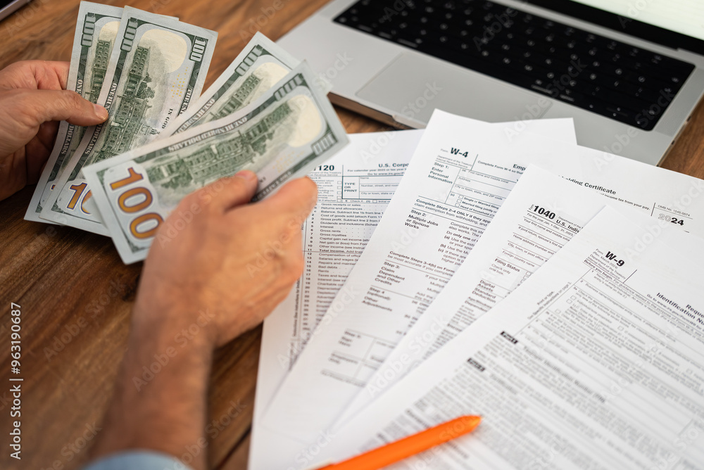 Poster man freelancer holds dollar bills in hands counting income for filling tax forms to report income me