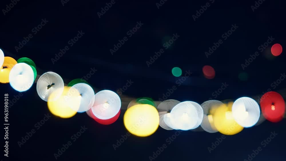 Poster string of colorful bokeh lights glowing in the night. the out-of-focus lights create a soft, dreamy 