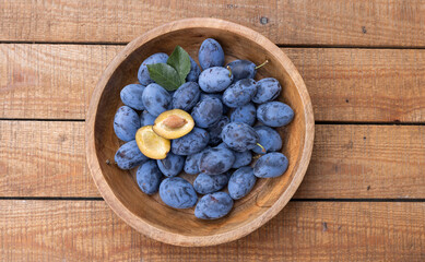 Frisch geerntete Ökologische Zwetschgen in einer Holzschale