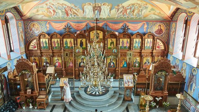 SUPRASL, POLAND - JUNE 1 2018: Little beautiful girl walks in Orthodox church of St. John Theologian in Monastery of Annunciation in Suprasl, also known as Suprasl Lavra is monastery, Poland