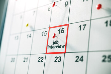 Closeup of a calendar with a job interview marked on the 16th with a red pin. 3D Rendering