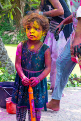 Little girl celebrating Holi with pichkari