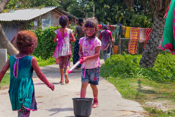 Group of happy Indian girls playing holi in the village