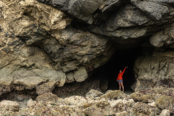 Woman Stands In Sea Cave At Low Tide