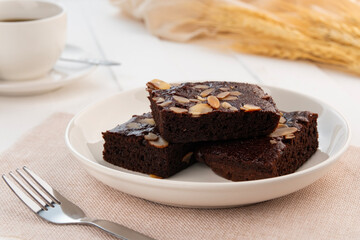 fudge almond brownies.Chocolate Brownie with Almond Sliced Topping in white plate.