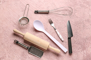 Different kitchen utensils on pink background