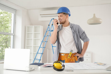 Male contractor talking on radio transmitter in room
