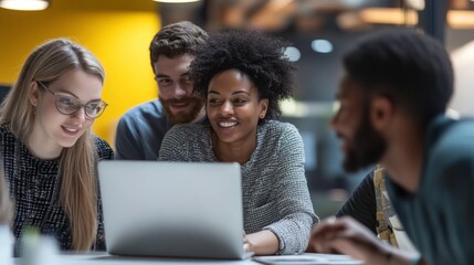 Diverse team collaborating on laptop in modern office setting