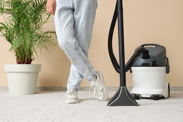 Fototapeta premium Woman cleaning carpet with vacuum cleaner at home