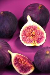 Whole and cut figs on a purple background.