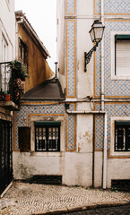 Fototapeta premium Narrow cobblestone street framed by colorful tiled facades