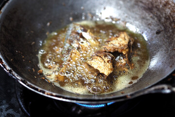 fish fried in a frying pan, fish frying in oil on the fire