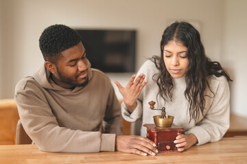 A Couple Joyfully Engages in a Playful Moment While Using a Traditional Spice Grinder at Home