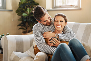 Sofa, couple and hug with laugh for joke, funny memory and bonding together in marriage at home....