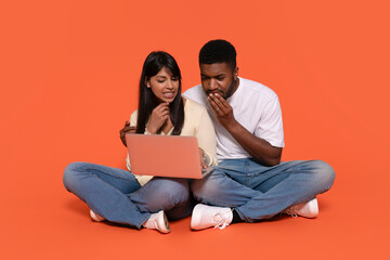 A Couple Sharing Bad News While Exploring Online Content on a Laptop Against a Vibrant Backdrop