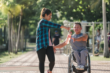 Obraz premium Girlfriend and Disabled man in wheelchair at the park. Muscular dystrophy. Young man in wheelchair and joyful woman at park.