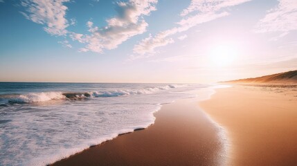 Waves gently rolling onto a quiet beach, with the sun low in the sky, creating long shadows and a peaceful vibe