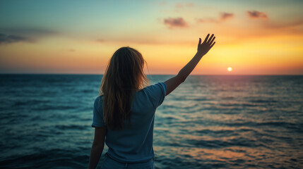 Woman waving goodbye by the beach. View taken from behind.