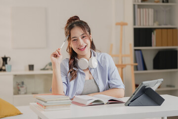 Young happy professional business woman worker employee sitting at desk working on laptop in corporate office. Smiling female student using computer technology learning online, doing web research.